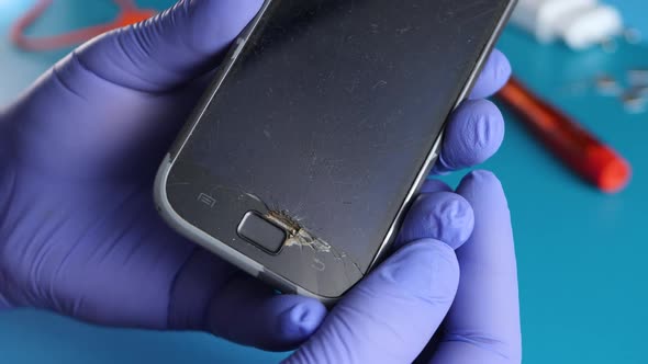 Unrecognizable Hand Holds Smartphone with Broken Touchscreen Display