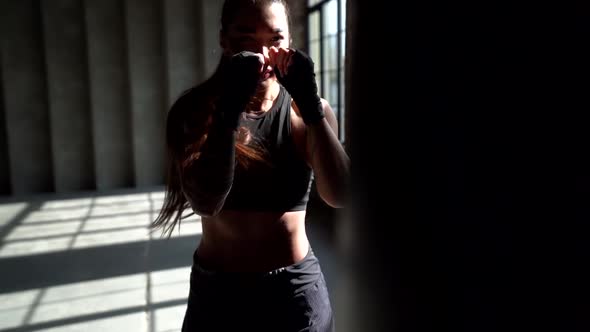 Female Kickboxer Is Training in Gym, Striking and Dodging From Punches alt