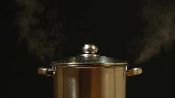 A Stream Breaks Out Of A Steel Pan On A Black Background