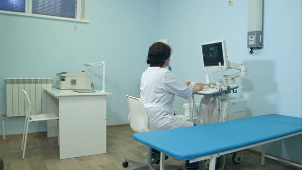 Woman Doctor Working at Ultrasound Diagnostic Machine alt