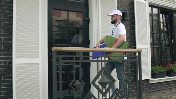 Postman Carrying Gift Box Knocking at Door alt