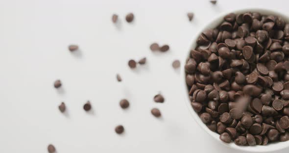 Video of overhead view of bowl of chocolate chip over white background alt