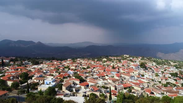 Aerial View of Village on Sunny Day Among Cloudy Mountains