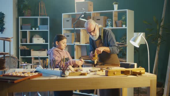 Teenage Girl with a Caring Grandfather Carpenter Learning to Works with Wood alt