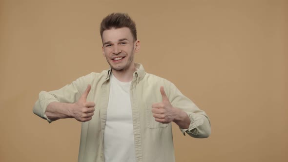 Portrait of Stylish Guy Showing Thumbs Up Gesture Like and Smiling alt