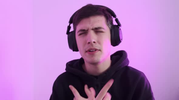 A Man Listens to Music on His Headphones and Sings Along alt