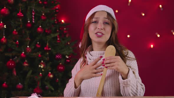 Joyful Attractive Woman in Santa Hat Singing Xmas Songs Using Kitchen Spatula