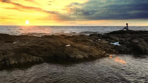 Woman looking at the Sunset on the Beach. alt