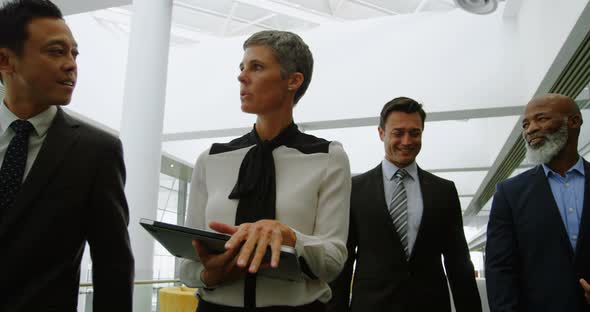 Business people discussing while walking in the office 4k alt