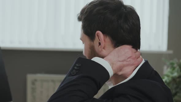 Close Up of an Office Worker Holding Sore Neck While Using Notebook Computer alt