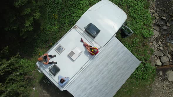 Family on Their Camper Van Motorhome Roof Enjoying the Sun alt