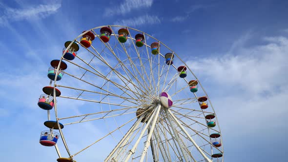 4k Time-lapse of Ferris Wheel at amusement park with blue sky background alt