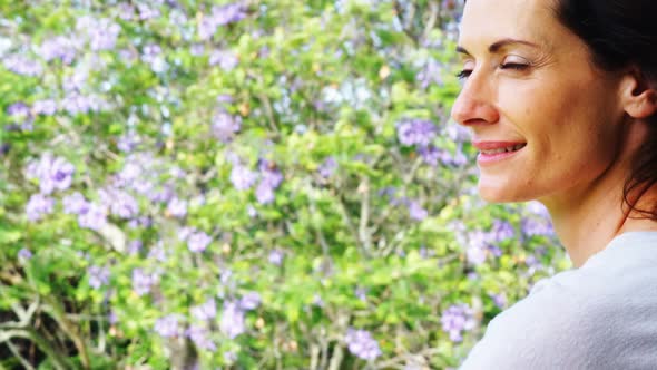 Smiling woman standing on a balcony and looking away alt