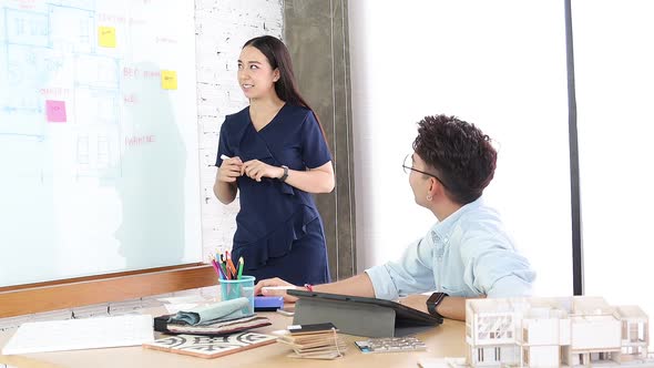 Asian  Interior Architect working with architectural model choosing material and study alt