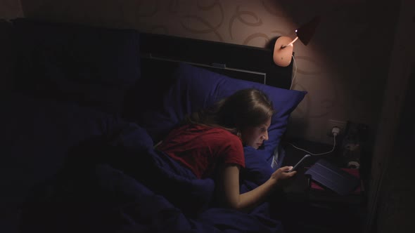 Young Girl Using Her Phone at Night