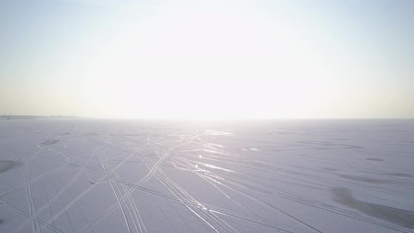 Flying Over Frozen Lake Against Sun