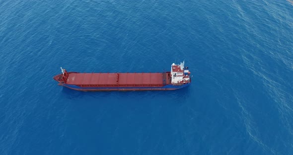 Aerial View. Red Deck Cargo Ship Sailing on Open Sea. alt