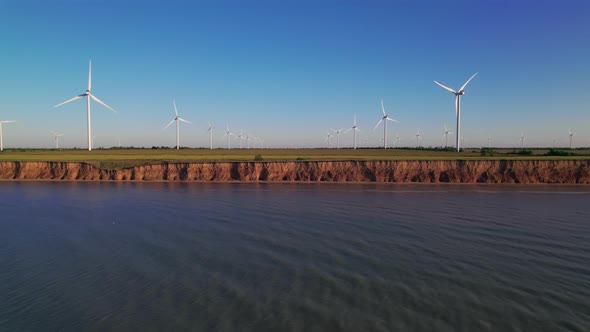 Windmills on a cliff above the sea, top view. Wind farm for wind energy.