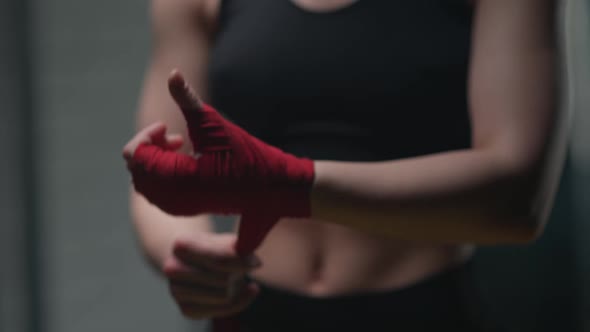 Anonymous Female Fighter Wraps Her Hands with Red Boxing Bandages Kickboxing Training Day in a Gym alt