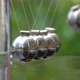 Newton&#39;s Cradle metal balls on green nature background, swinging metal balls, Macro shot. Close up. - VideoHive Item for Sale