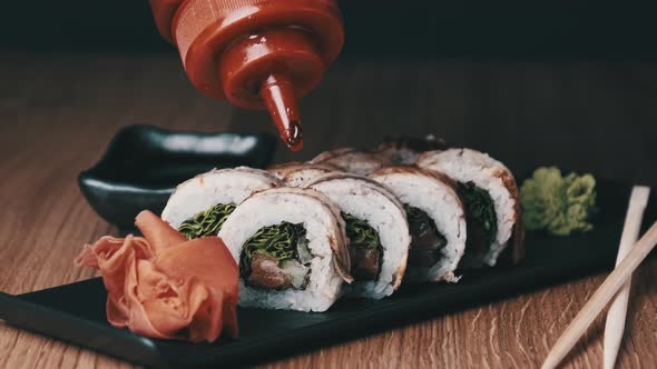 Appetizing Sushi is Poured with Sweet Sauce on a Wooden Table in Restaurant alt