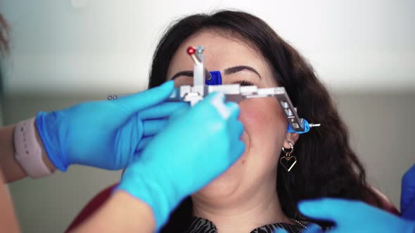 Dentist in Medical Gloves Using Special Tool Examines Patient in Dental Clinic alt