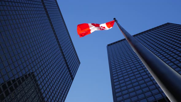 Rotating Around Tall Office Buildings Downtown With Tall Canadian Flag In Daylight