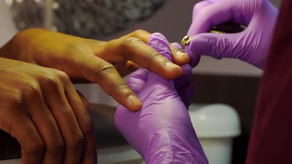 Closeup of Manicure Process and Master Hands Removing Cuticle From Fingernails alt