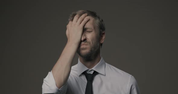 Stressed frustrated businessman making a facepalm gesture