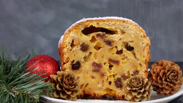 Powdered sugar poured onto Christmas Stollen fruit cake on dark background Festive pastry baking 4K alt