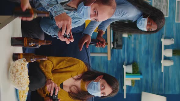 Vertical Video Concentrated Multiracial Friends Playing Video Games with Joystick alt