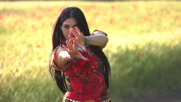 Gypsy girl in a field of poppies dancing in slow motion.