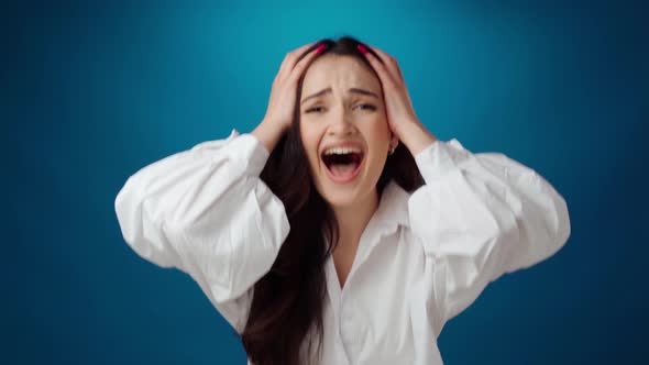Frustrated Nervous Woman Screaming Nad Touching Head Against Blue Background