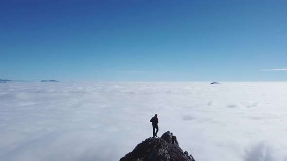 Hiker on viewpoint, above the clouds, Lecco, Lombardy, Italy