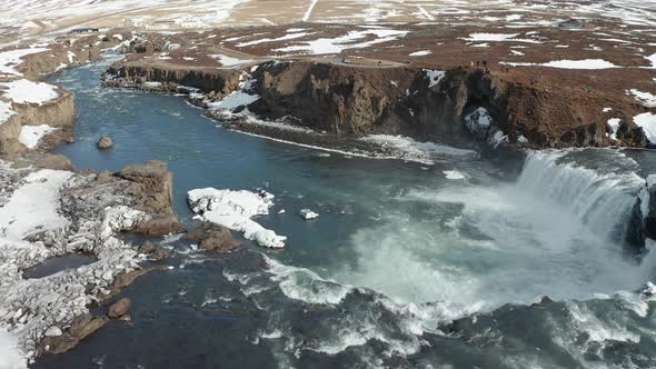 Aerial View of Godafoss Waterfall with Snowy Shore and Ice. Iceland