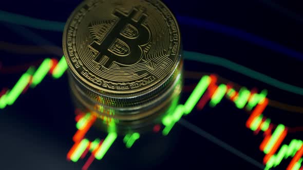 Golden Bitcoin Coins are Rotating on a Candles Chart Background alt