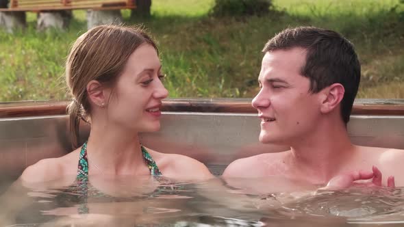 Couple Chatting in Hot Tub Outdoors alt