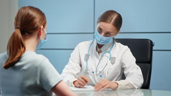 Lady medical consultant in facial mask and white coat alt
