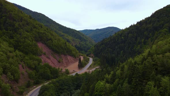 Steep green mountains, deep forest and mountain road, beautiful valley alt
