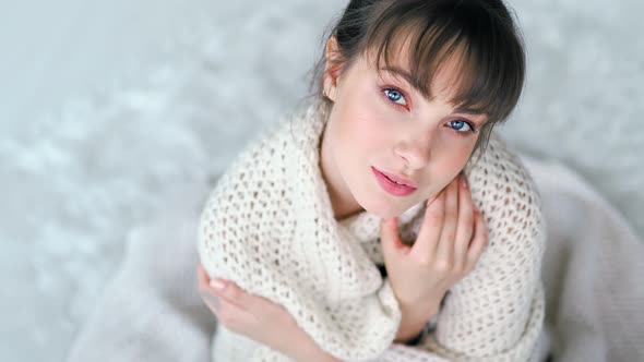Romantic Young European Woman Getting Warm Wrapped in White Knitted Plaid alt