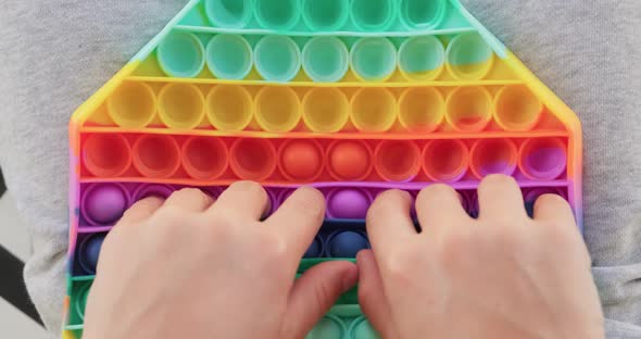 Close up of boy playing popit toy. alt
