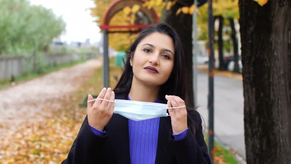 Young woman wears surgical mask in the time of the Covid-19 pandemic. Autumn