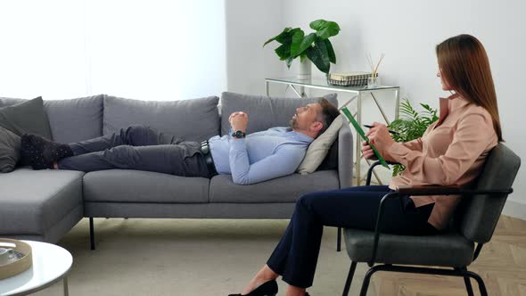 Woman Psychologist Sitting on Chair Listens Patient at Psychotherapy Session alt