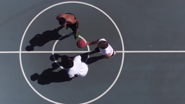 Friends playing basketball at park, overhead shot of tip off