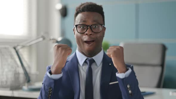 Portrait of Excited African Businessman Celebrating Success alt