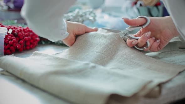 Hands Cut the Fabric for the Christmas Wreath with Scissors alt