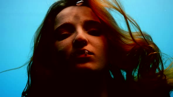 Pretty Water Nymph in Blue Water of Sea or Ocean Closeup Portrait Woman is Exhaling White Smoke alt