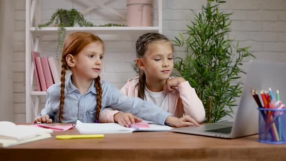 Two Little Children Girl Using Laptop for Doing School Tasks at Home