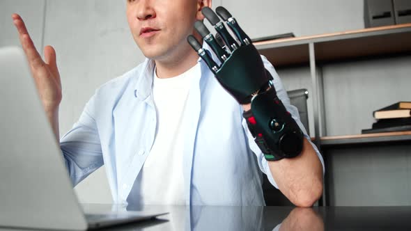 Programmer freelancer man with bio hand prothesis talks at online video alt
