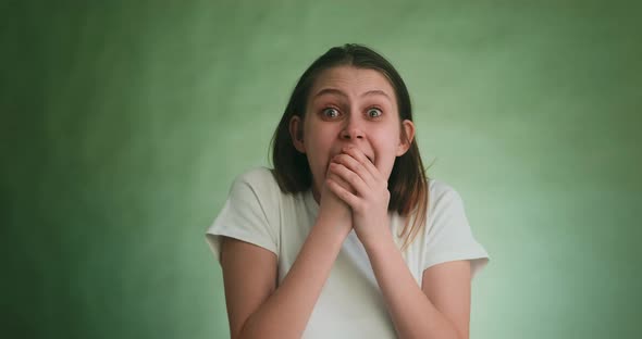 Woman with Tears in Eyes Screams Loudly with Fear on Green alt